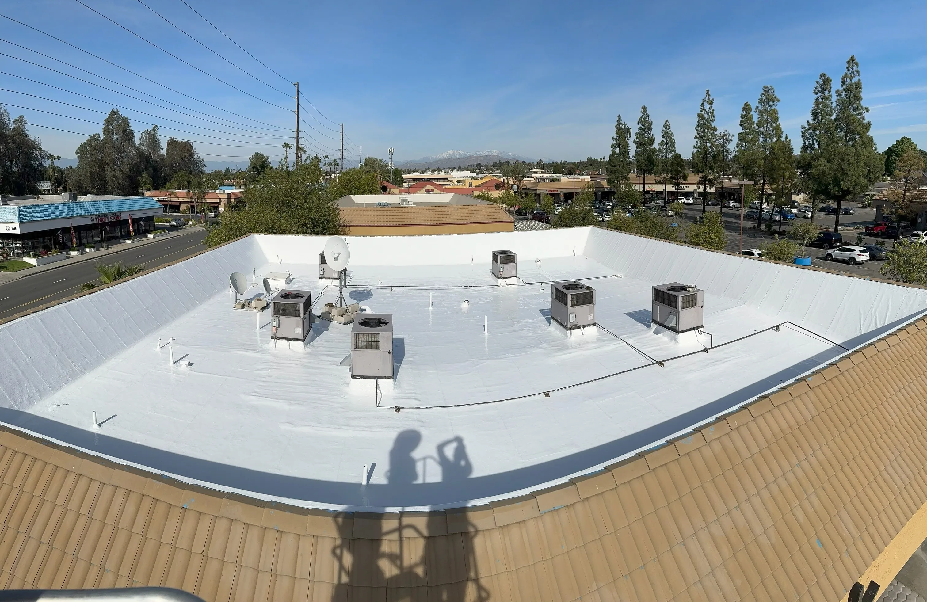 Same commercial flat roof after a white silicone restoration coating was applied